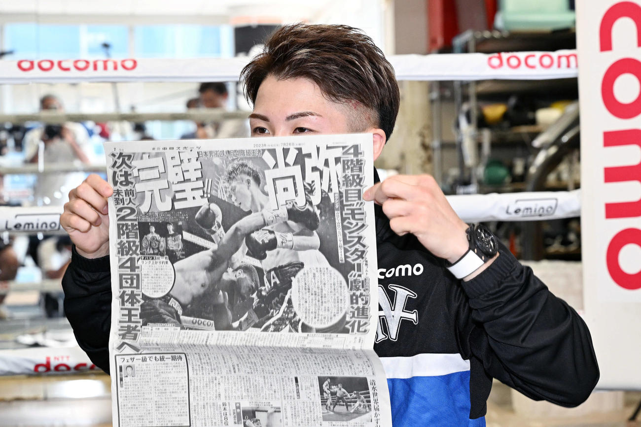 WBC、WBO世界スーパーバンタム級タイトルマッチの一夜明け会見で試合が掲載された新聞に隠れておどける井上（撮影・滝沢徹郎）
