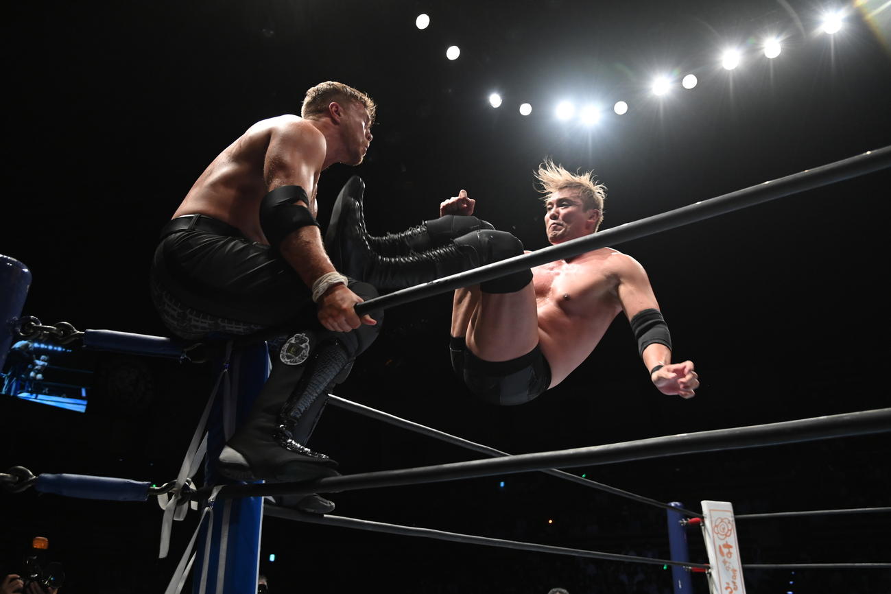 ウィル・オスプレイに高いジャンプからドロップキックをしかけるオカダ・カズチカ（新日本プロレス提供）