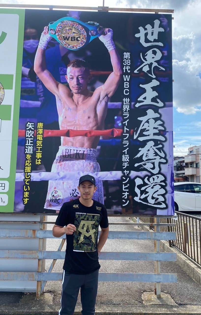 「世界王座奪還」の看板前でポーズを決める矢吹（矢吹選手提供）