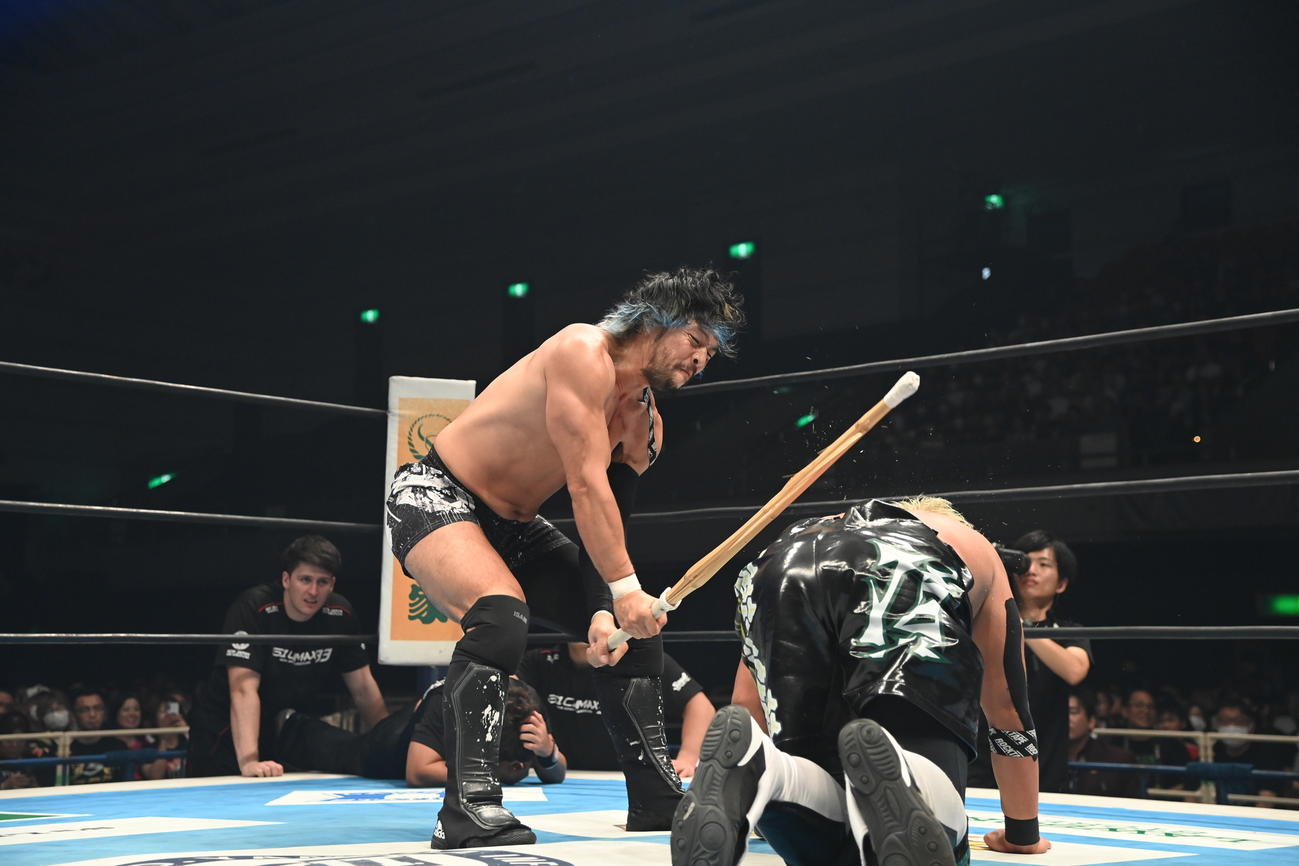 YOSHI－HASHIに対して、竹刀で打ち込むKENTA（右）（新日本プロレス提供）