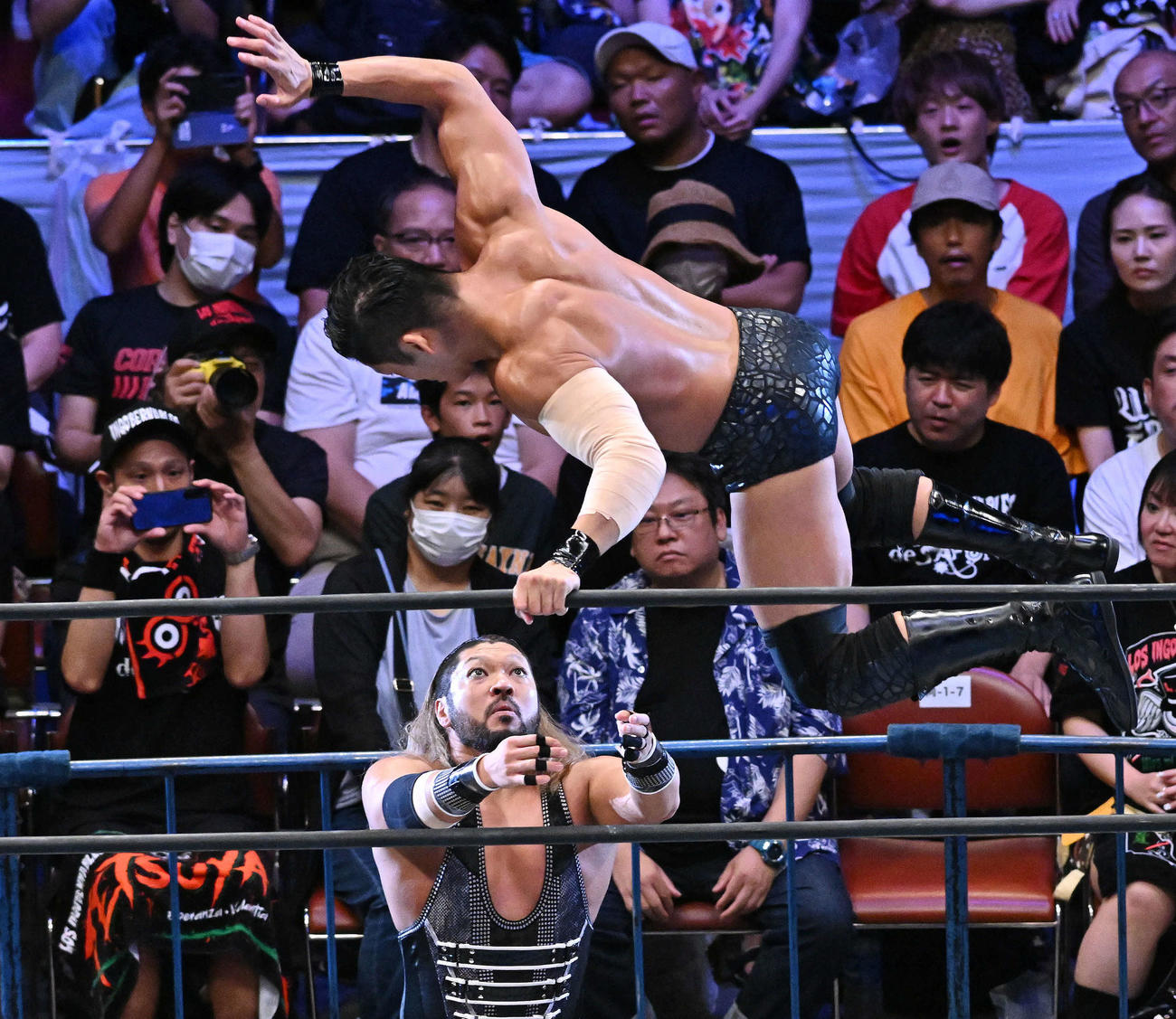8人タッグマッチでSANADA（上）は場外のEVILに飛び込む（撮影・滝沢徹郎）