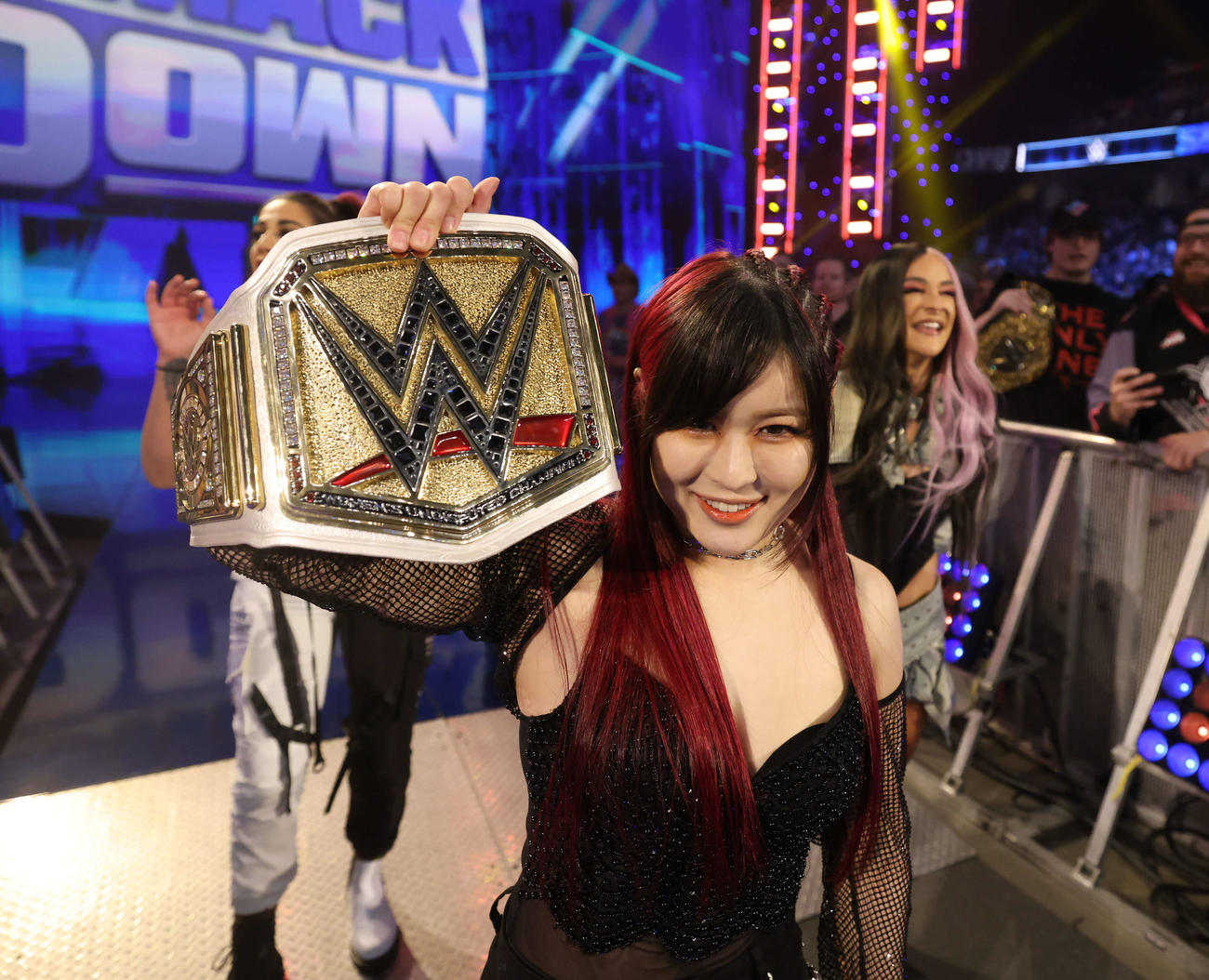 WWE女子王座ベルトを掲げるイヨ・スカイ（中央）（C）2023 WWE, Inc. All Rights Reserved.
