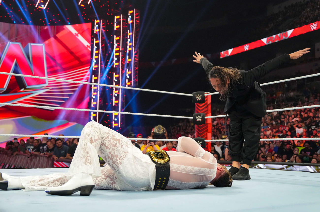 WWE世界ヘビー級王者セス・ロリンズ（手前）をキンシャサ葬し、ふてぶてしく頭を下げる中邑真輔（C）2023 WWE, Inc. All Rights Reserved.