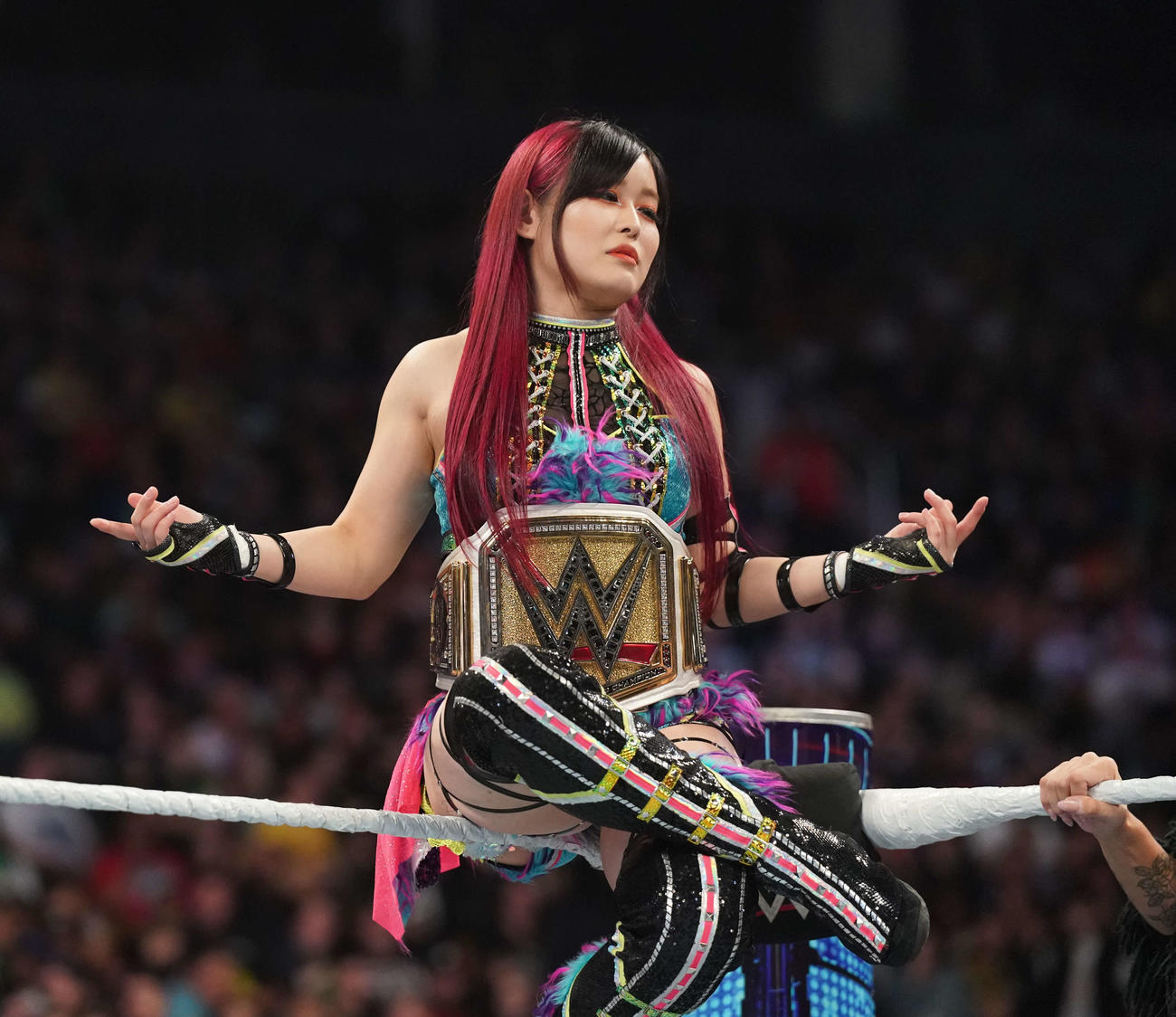 トップロープに座り、WWE女子王座ベルトを誇示する王者イヨ・スカイ（C）2023 WWE, Inc. All Rights Reserved.