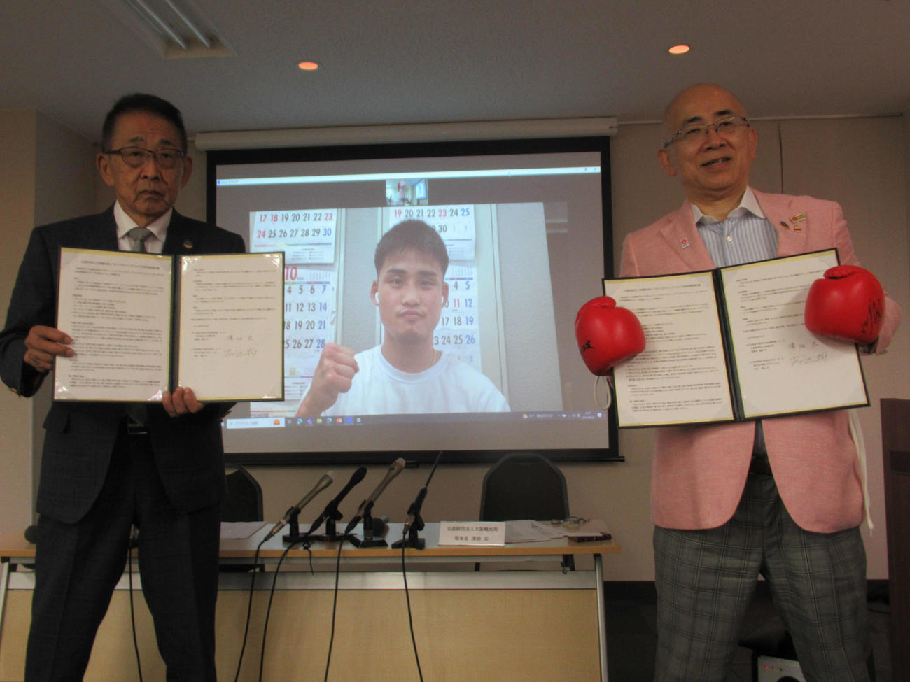提携を結んだ大阪観光局の溝畑理事長（右）とワタナベジム渡辺会長（左）。中央はオンライン参加の元2階級制覇王者の京口（撮影・実藤健一）