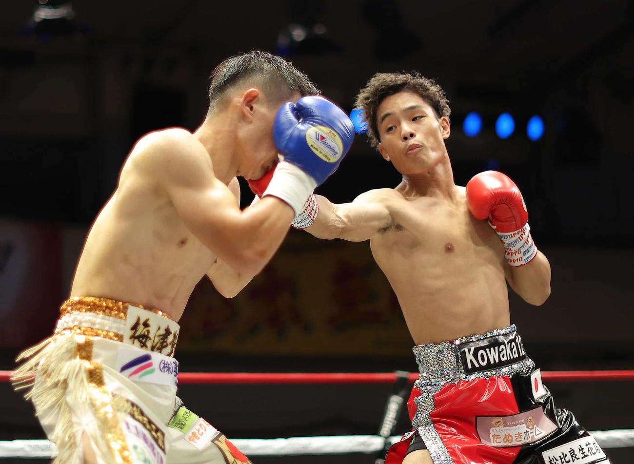 1回、梅津（左）にパンチを見舞う穴口（撮影・河田真司）