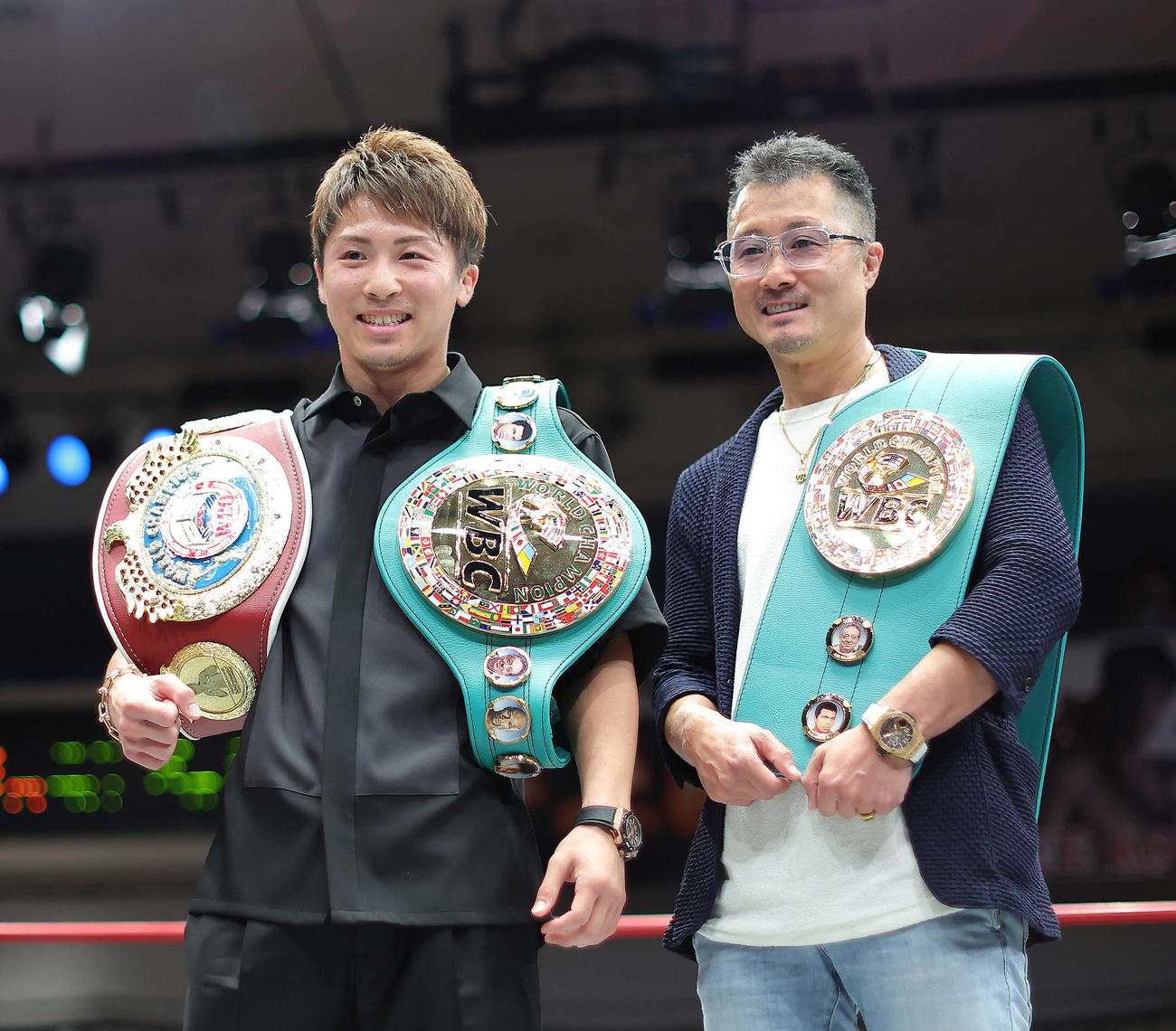 WBC、WBO世界スーパーバンタム級のベルト贈呈式で、チャンピオンベルトを肩に笑顔で写真に納まる井上尚弥（左）と父・真吾氏（撮影・河田真司）