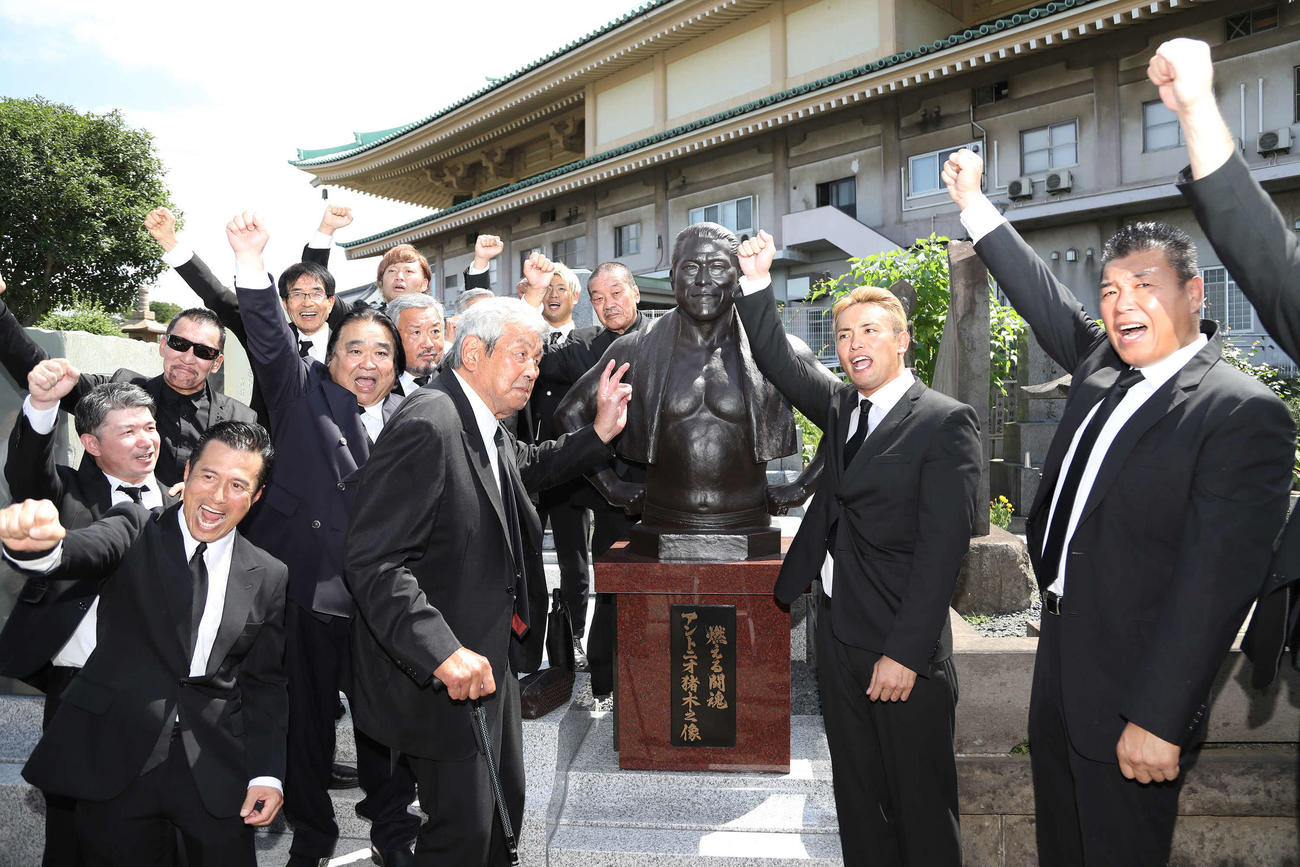 除幕されたアントニオ猪木さんのブロンズ像前で「1、2、3、ダー！」をする参列者（撮影・丹羽敏通）