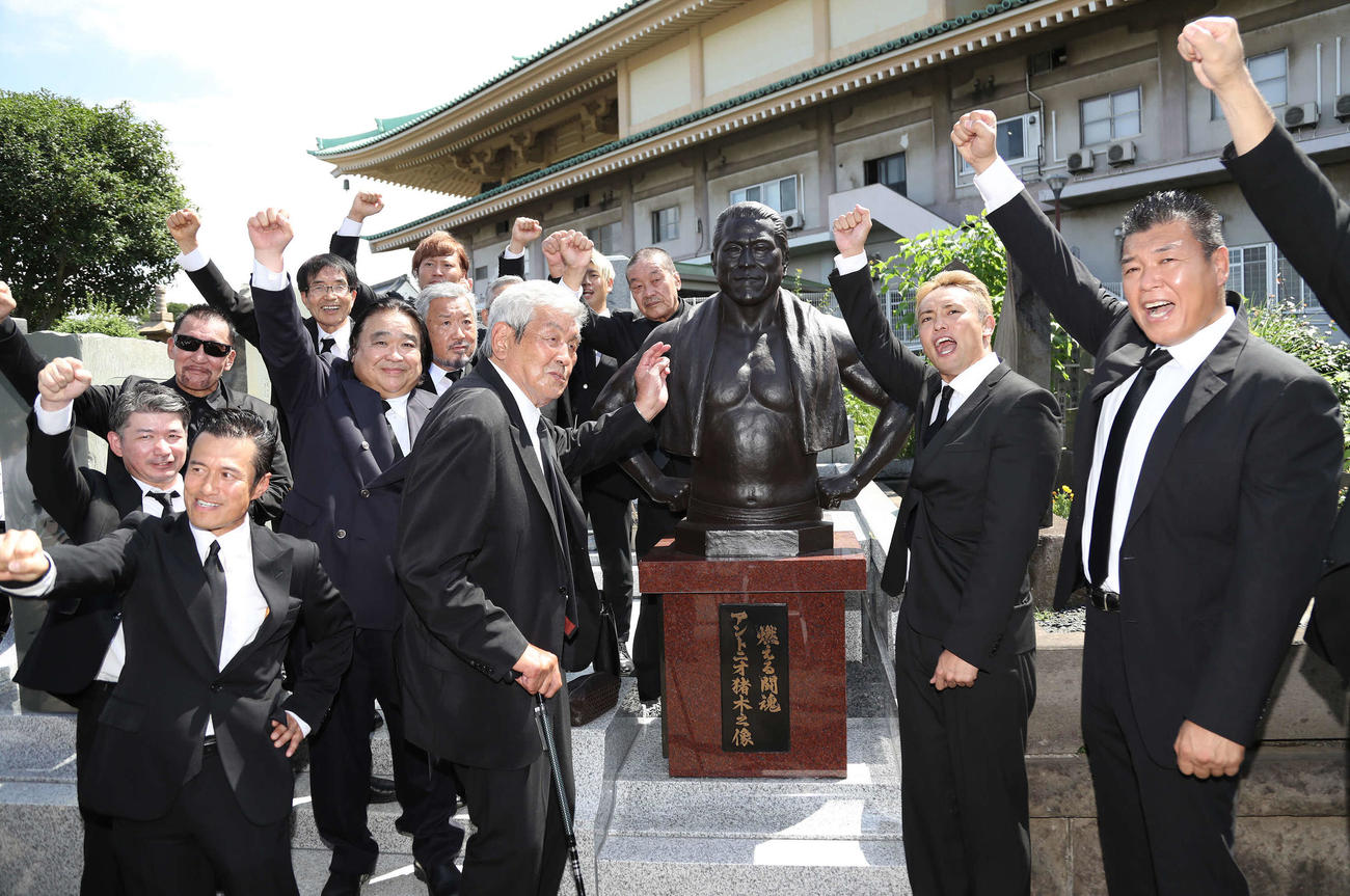 除幕されたアントニオ猪木さんのブロンズ像前で「1、2、3、ダー！」をする参列者（撮影・丹羽敏通）