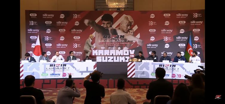 RIZINアゼルバイジャン大会カード発表で、会見の机に立つ鈴木千裕（左から5人目）（RIZINのYouTubeから）
