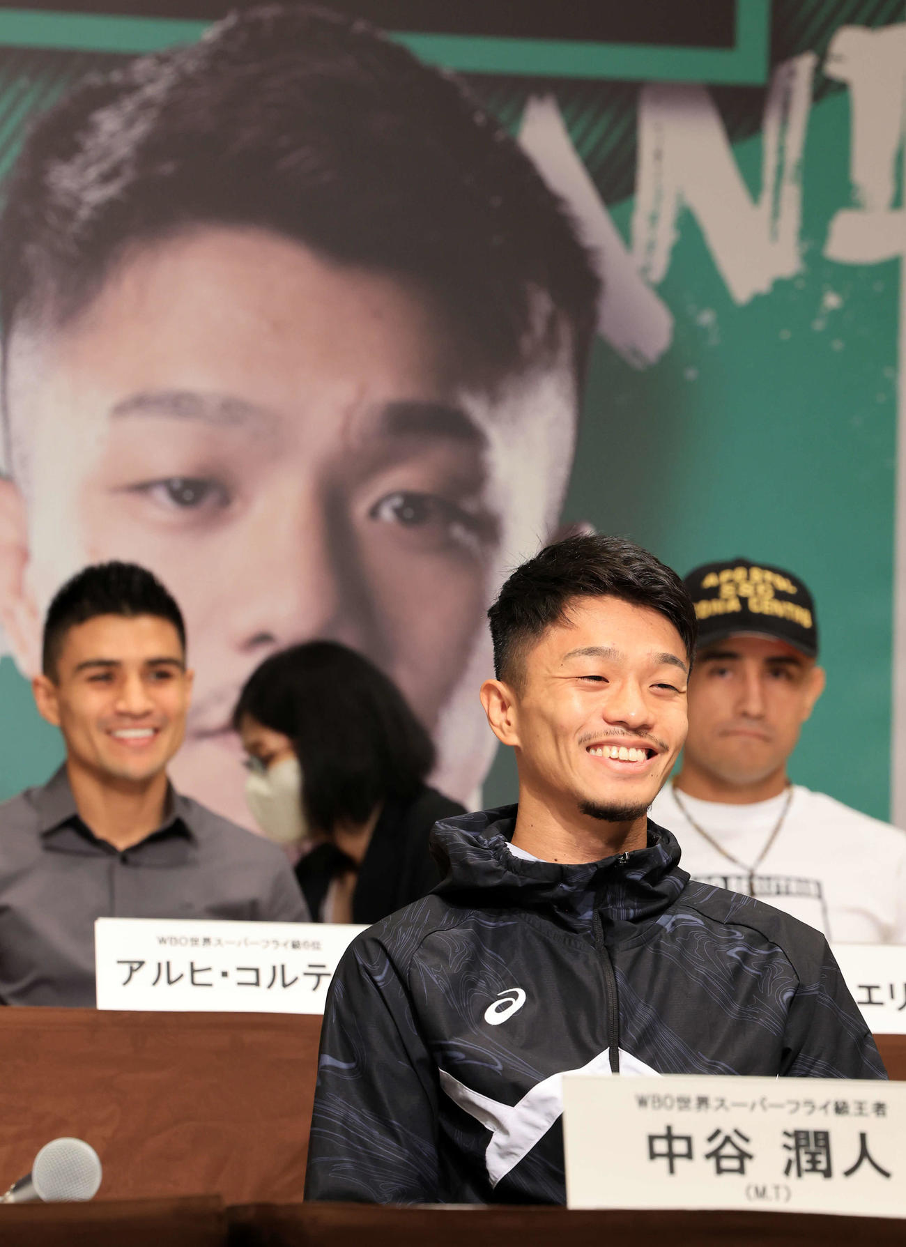 「LIVE BOXING 5」の会見で自身のパネルを背に笑みを浮かべる中谷潤人（手前）。後方左はアルヒ・コルテス（撮影・浅見桂子）