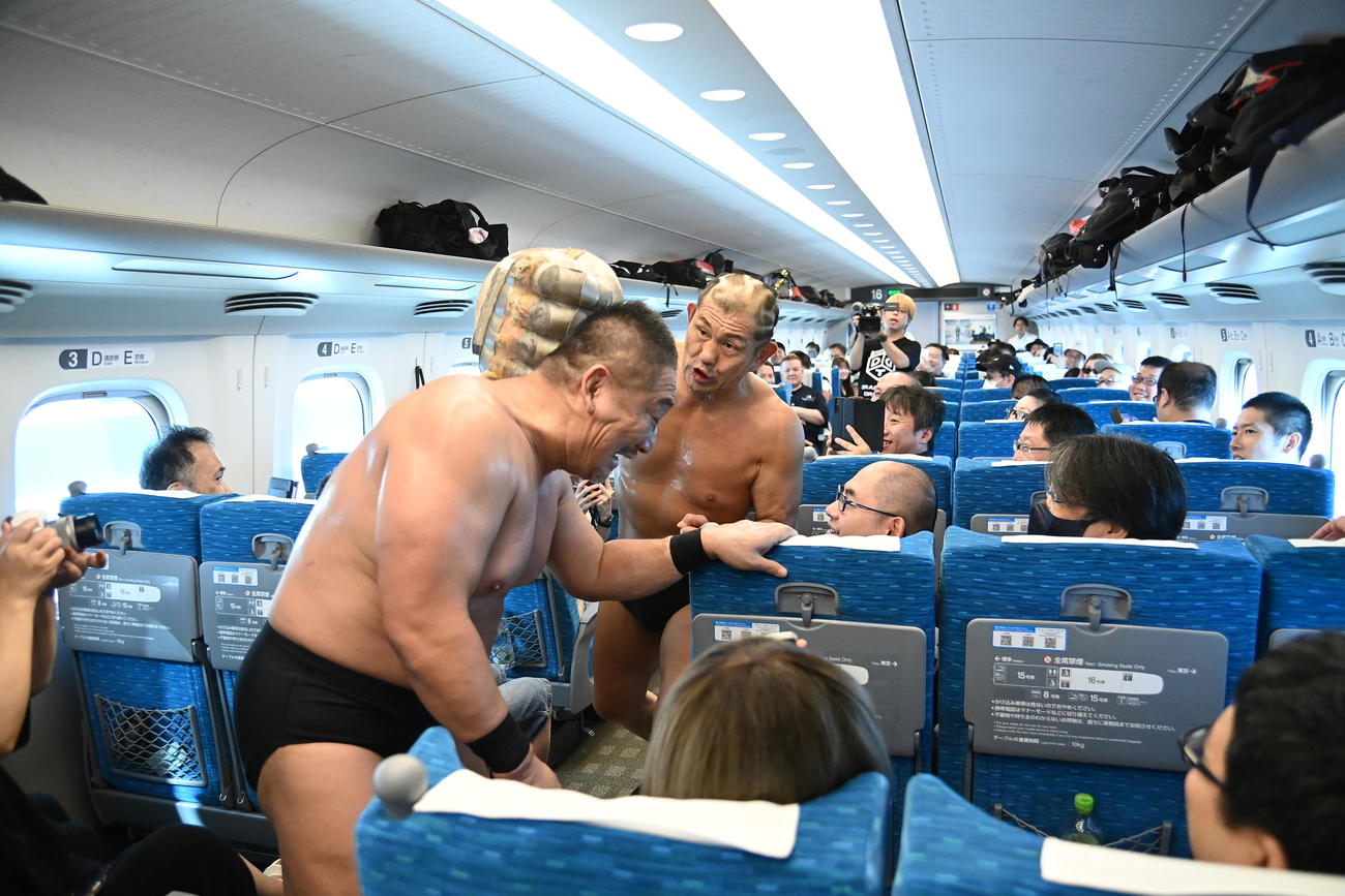 史上初の新幹線プロレスで、高木三四郎（左）にロケットパンチで襲いかかる鈴木みのる（DDTプロレス提供）