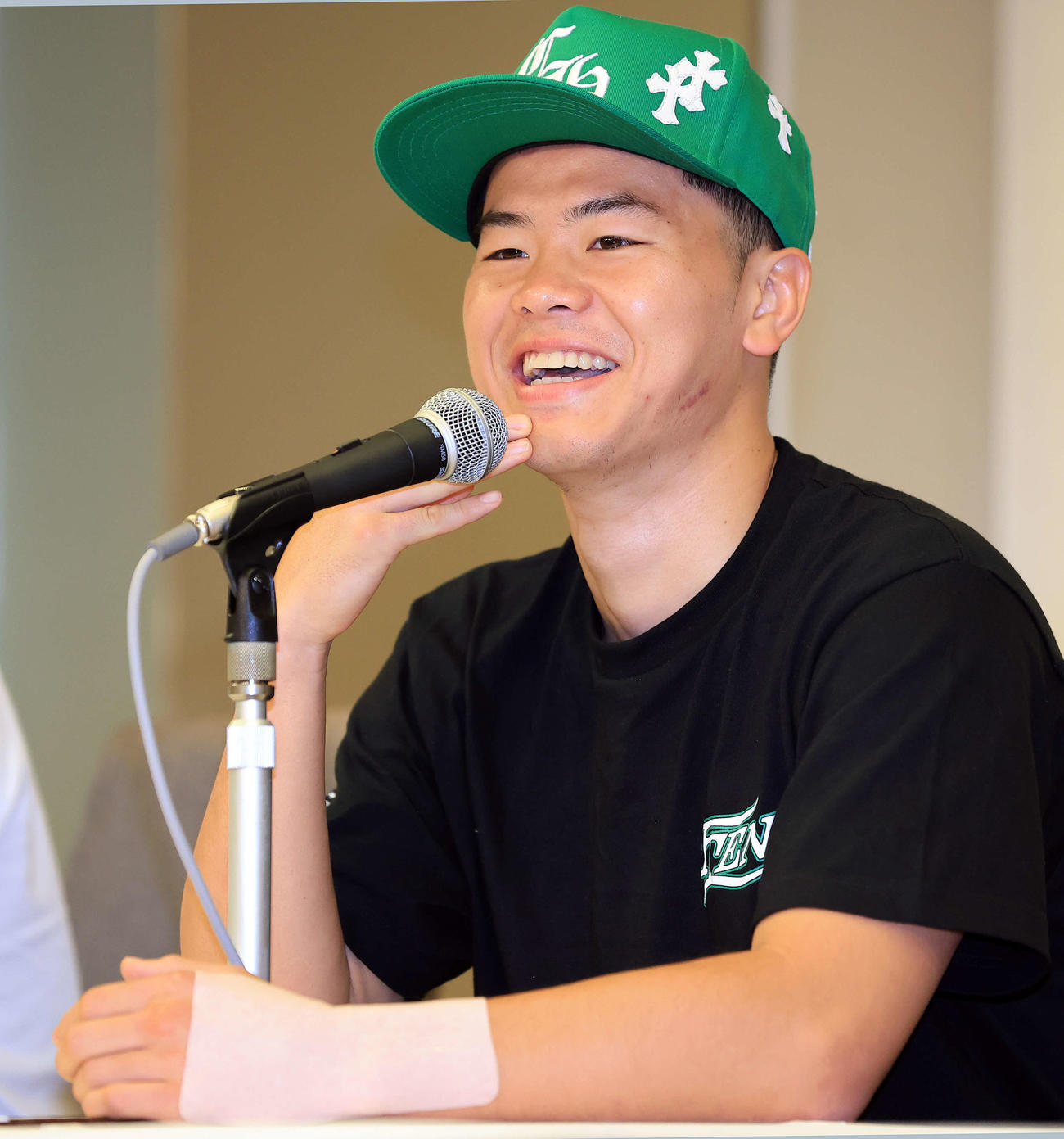 2勝目から一夜明け、左手にテーピングをし、笑顔で会見に臨む那須川（撮影・浅見桂子）