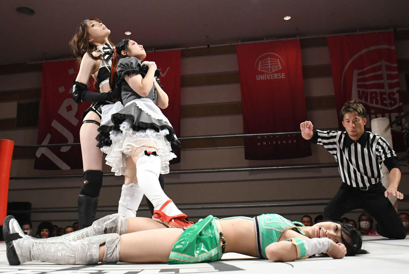 東京女子プロレス横浜大会　横たわる鈴木志乃を踏みつけ、ポーズを取るメイ・サン＝ミッシェル。左は沙希様（東京女子プロレス提供）