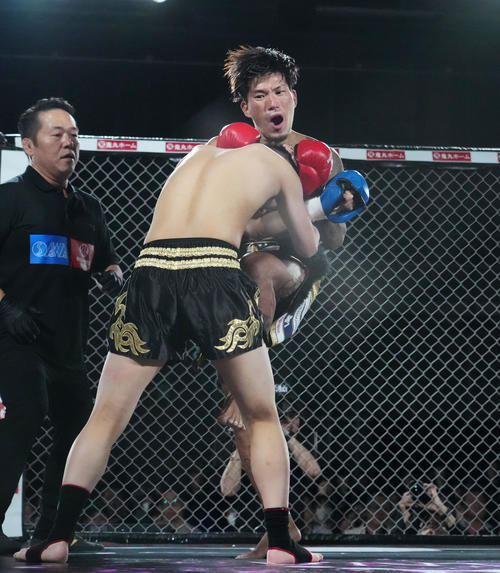 レオ（手前）にひざ蹴りをヒットさせるシェンロン（撮影・菅敏）