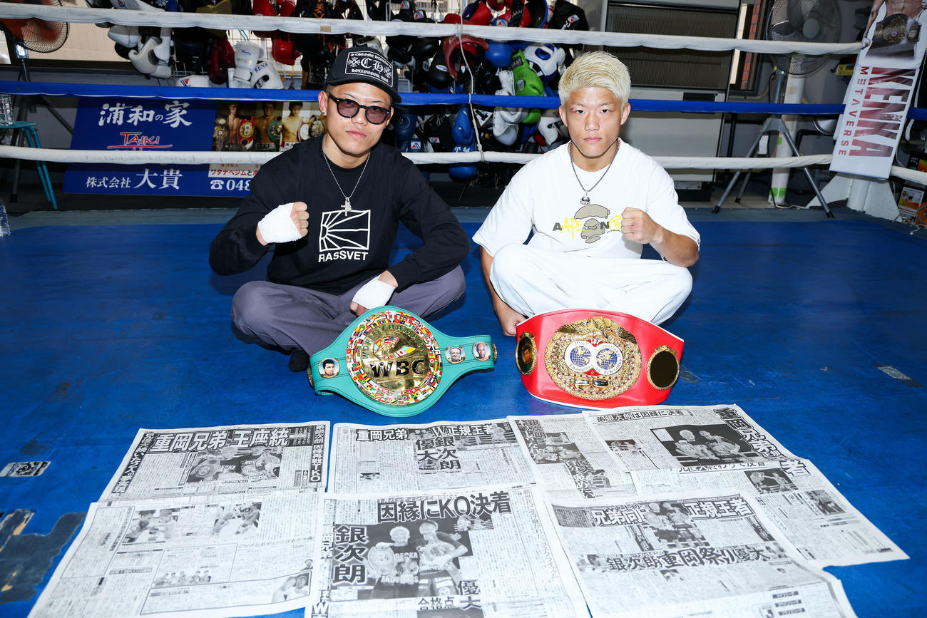兄弟同時王座統一から一夜明け、各紙面を並べ写真に納まる重岡優大（左）と弟の銀次朗（撮影・河田真司）
