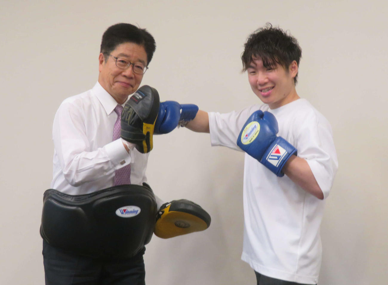 加藤勝信前厚労相（左）とミット打ちするWBAスーパー、WBC世界ライトフライ級王者寺地拳四朗