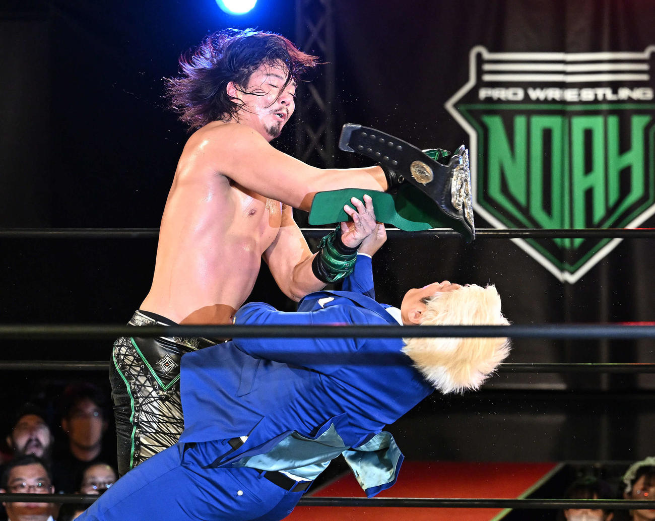 ジェイク・リー（左）はGHCヘビー級チャンピオンベルトで拳王を殴りつける（撮影・滝沢徹郎）