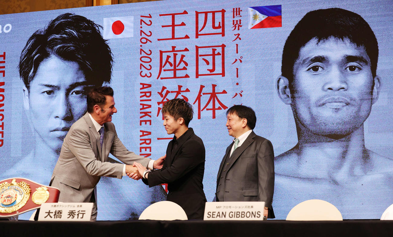 マーロン・タパレスとのWBA・WBC・IBF・WBO世界スーパーバンタム級王座統一戦の発表会見で、タパレスのプロモーター、MPプロモーションズのギボンズ社長（左）と握手する井上尚弥。右は大橋ジムの大橋会長（撮影・野上伸悟）