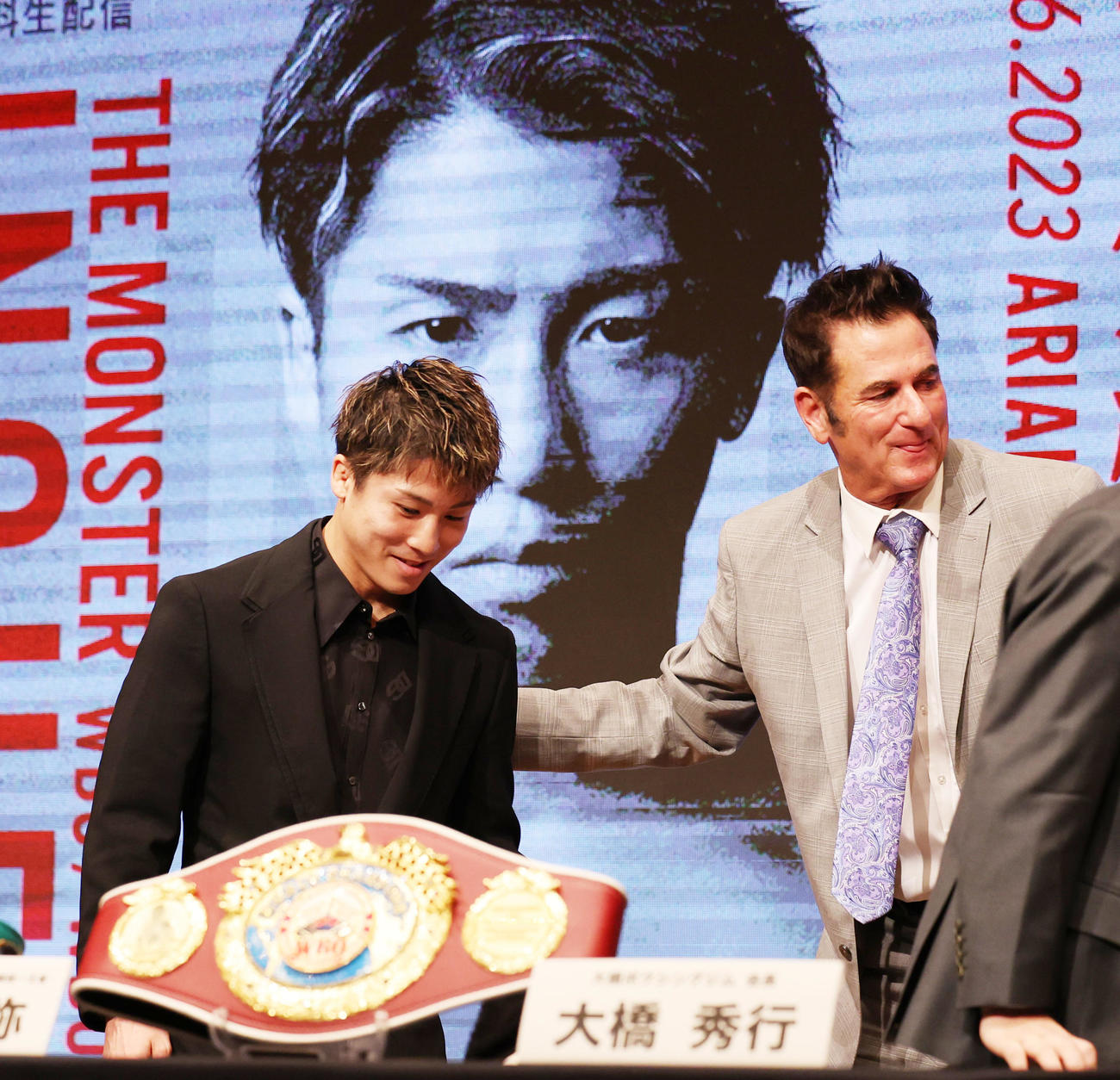 タパレスとのWBA・WBC・IBF・WBO世界スーパーバンタム級王座統一戦の発表会見で、タパレスのプロモーター、MPプロモーションズのギボンズ社長（右）とあいさつを交わす井上尚弥（撮影・野上伸悟）