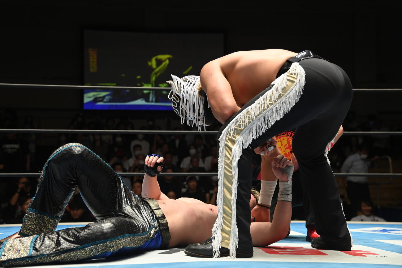 リング上で横たわるマスター・ワトに、何か話しかけるエル・デスペラード（新日本プロレス提供）
