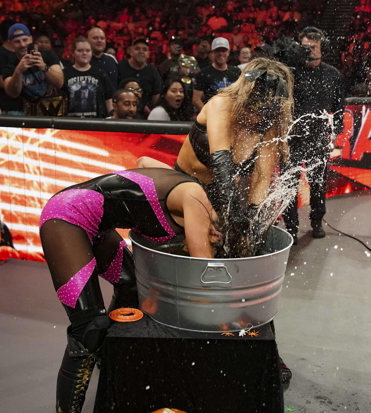 りんごと水の入ったバケツにチェルシー・グリーン（左）の顔をうずめるナタリア（C）2023 WWE, Inc. All Rights Reserved.