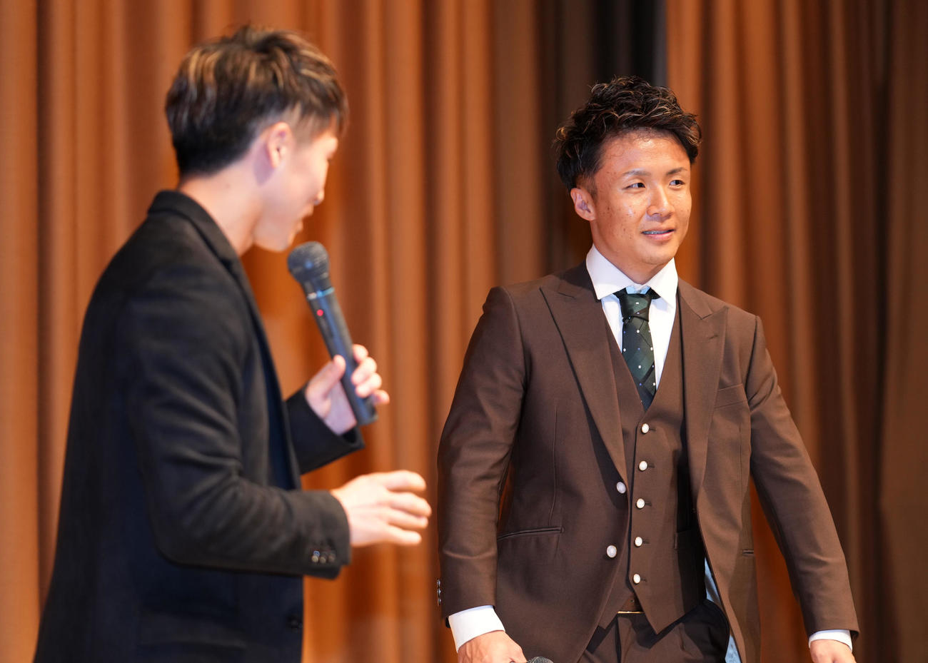 井上尚（左）からの紹介で壇上へ上がる山口（撮影・横山健太）