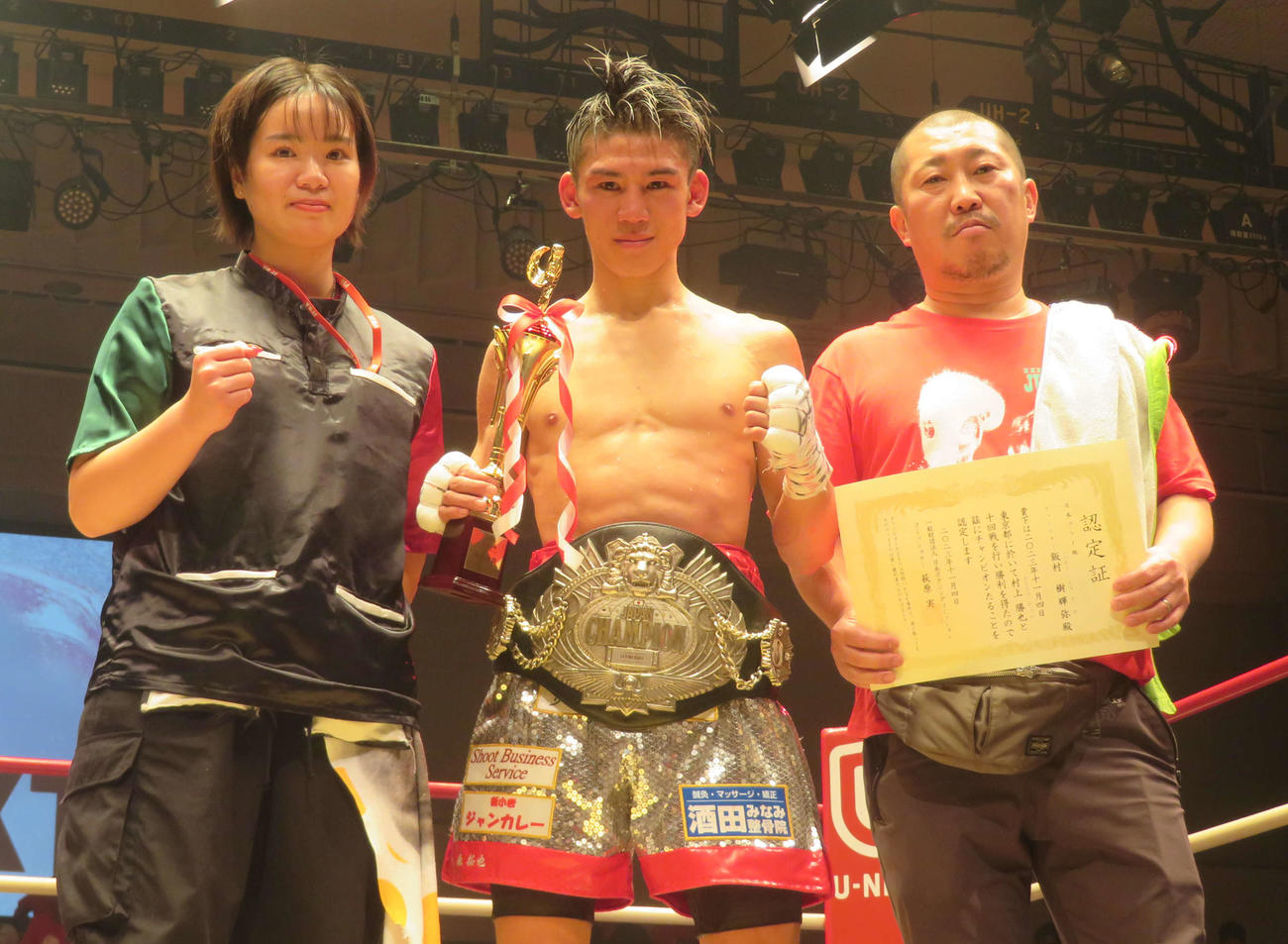 初防衛に成功した日本フライ級王者飯村樹輝弥（中央）。左は真成美夫人、右は佐藤直樹トレーナー