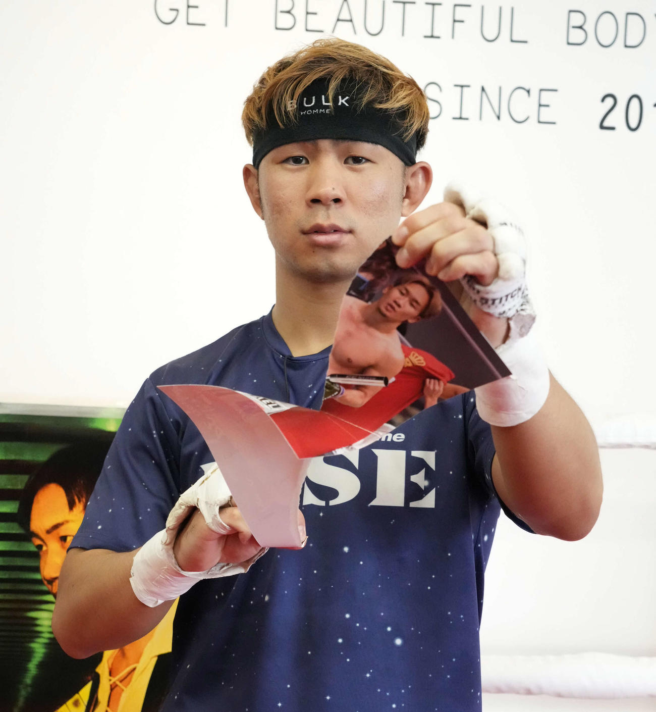 公開練習後にカメラマンの要望を受け朝倉未来の写真を破くYA－MAN（撮影・小沢裕）
