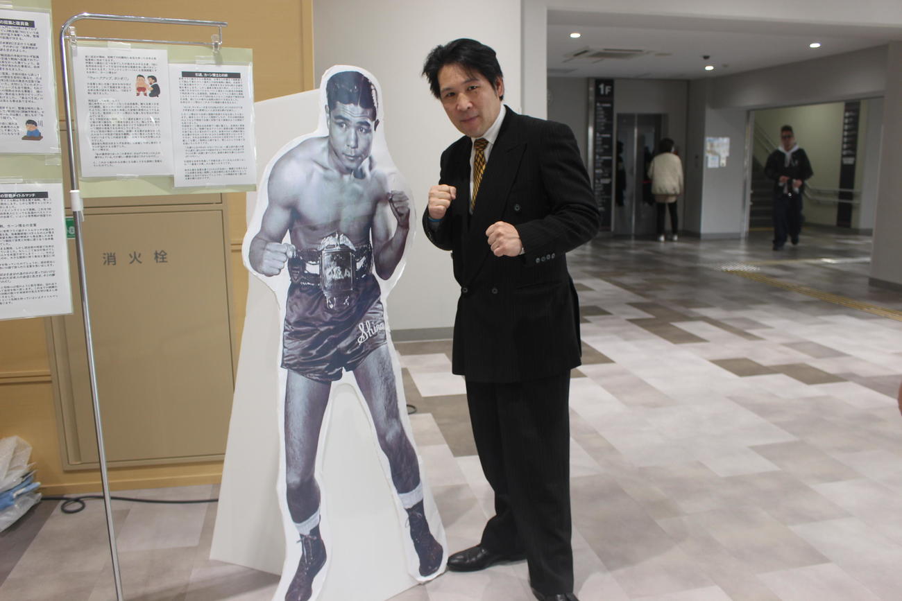 白井義男生誕100年イベントで等身大パネルと並んでポーズを取る坂本博之氏（撮影・首藤正徳）