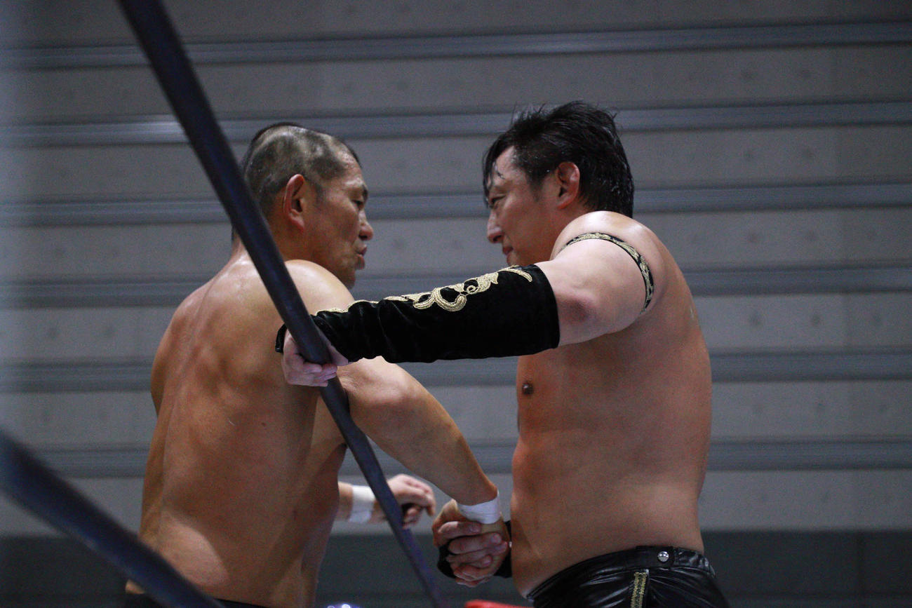 試合後、元同門タイチと握手する鈴木みのる（左）（新日本プロレス提供）
