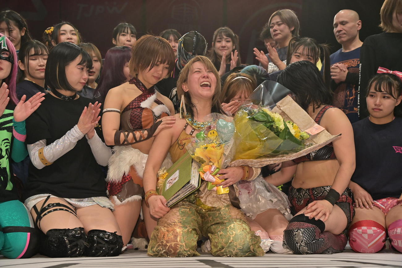 東京女子プロレス　大号泣の瑞希（前列右から3人目）の隣で、笑顔で振る舞う坂崎ユカ（中央）（東京女子プロレス提供）