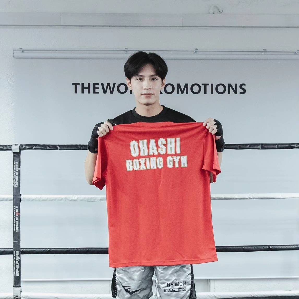 大橋ジムのTシャツを手にする韓国の人気俳優ド・ジハン（大橋ジム提供）