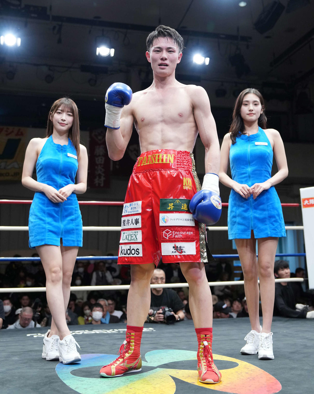 勝利を収めポーズを決める磯谷。後方左からラウンドガールの雪平莉左、天野レナ（撮影・小沢裕）