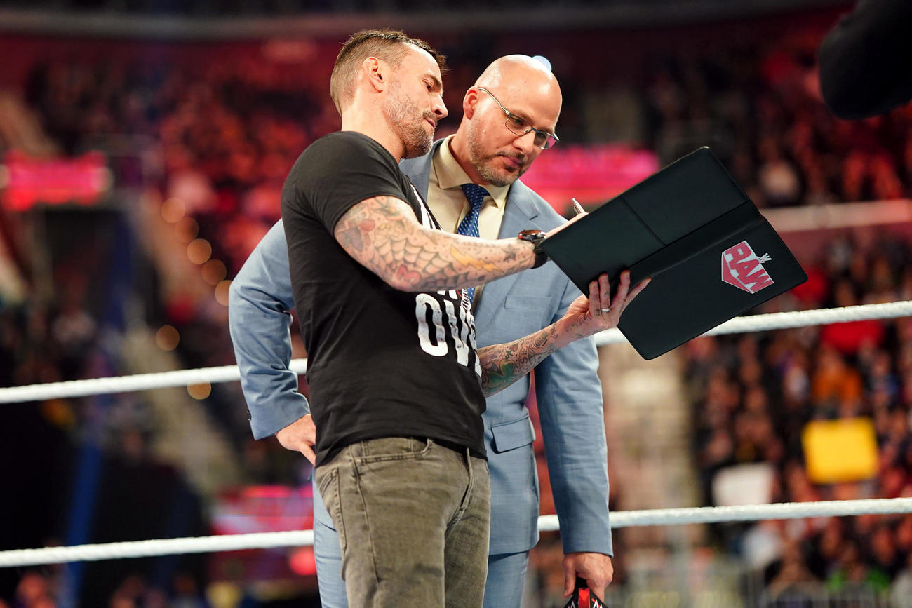 ロウのアダム・ピアースGM（右）が見守る中、ロウ所属の契約書にサインするCMパンク（C）2023 WWE, Inc. All Rights Reserved.