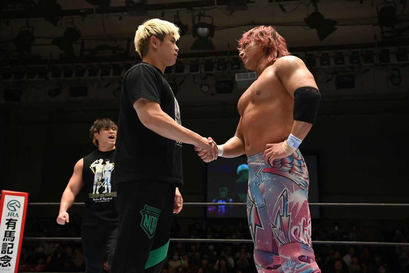 清宮海斗（中央）と海野翔太はがっちり握手。左は大岩陵平（写真提供・新日本プロレス）