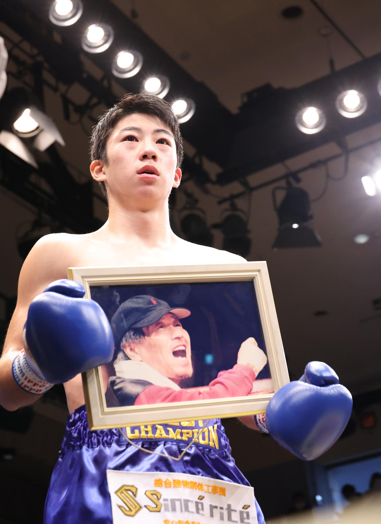 全日本新人王スーパーバンタム級王者に輝き松田鉱二前会長の遺影を手にインタビューに答える武藤（撮影・中島郁夫）