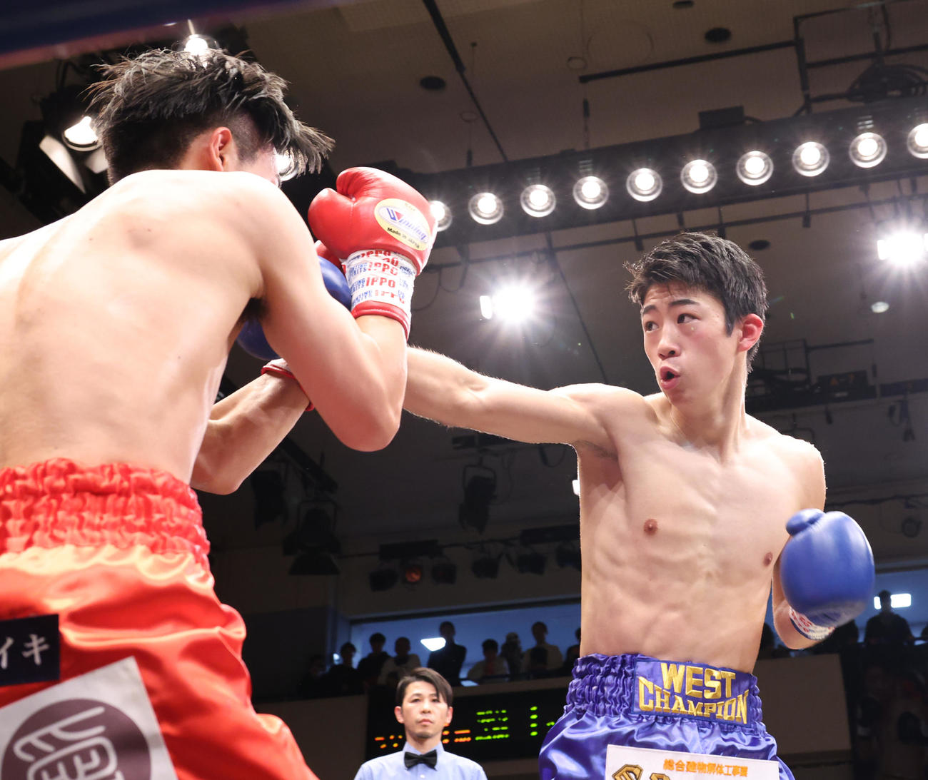 須藤（左）に右ストレートを浴びせる武藤（撮影・中島郁夫）
