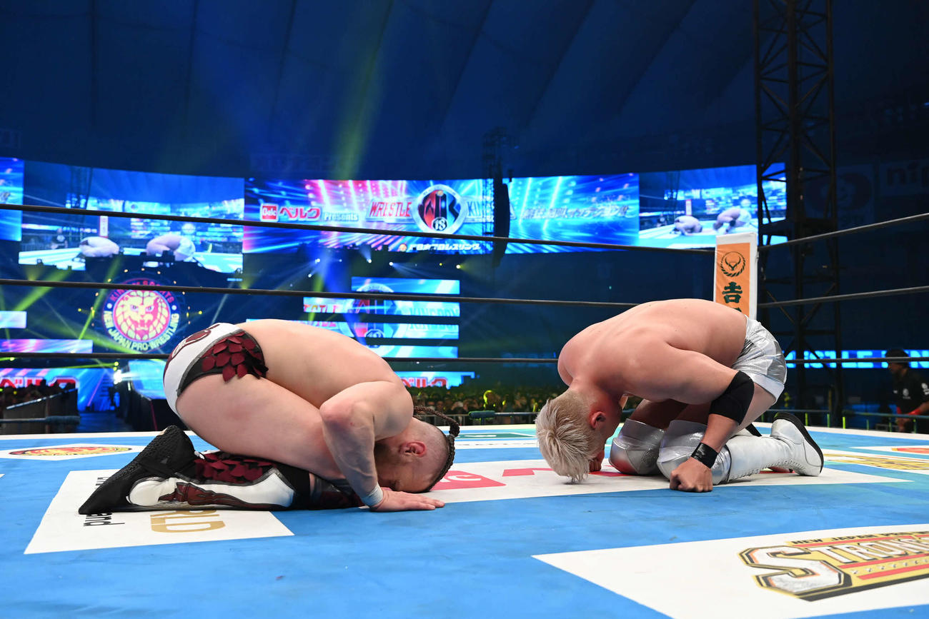 試合後、健闘を称え合って座礼するダニエルソン（左）とオカダ（C）新日本プロレス