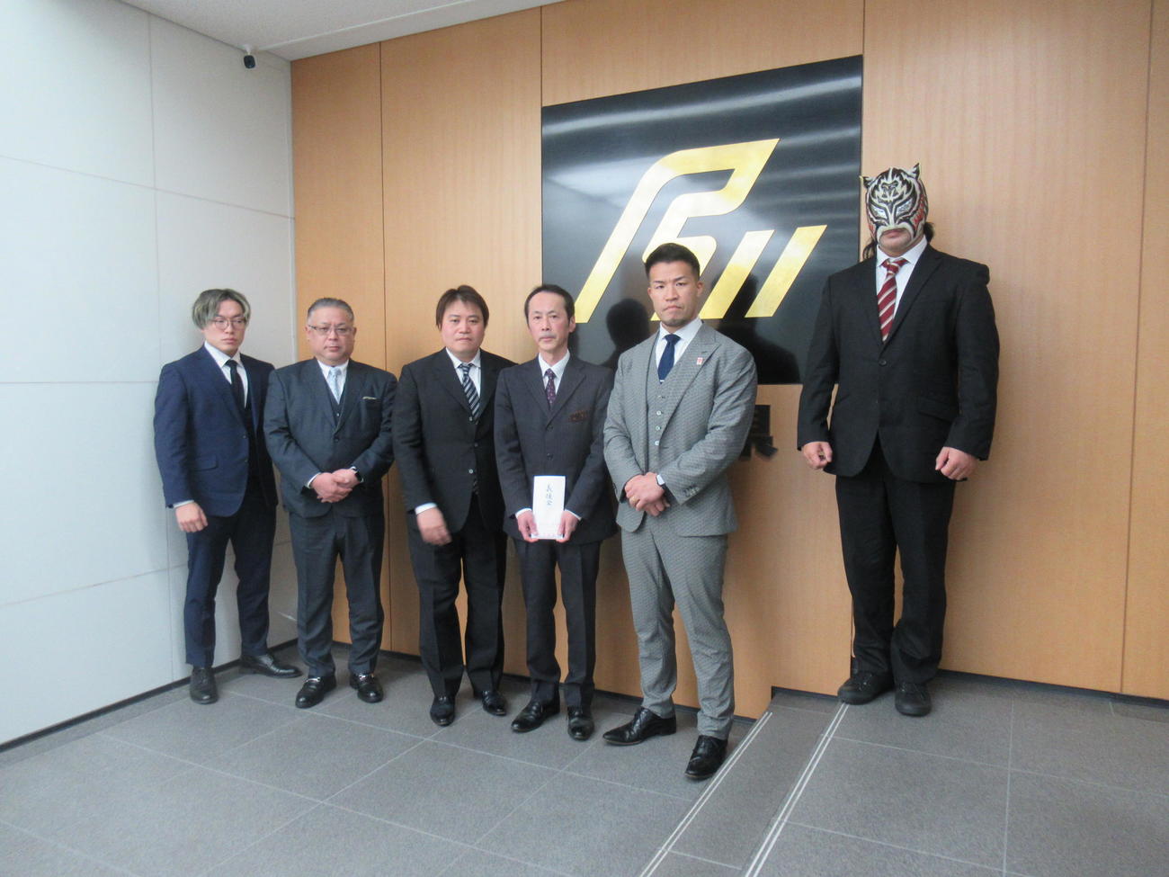 大阪プロレスのゼウス社長（右から2人目）は、義援金100万円を、石川県大阪事務所の山下幸則所長（同3人目）に手渡しした（撮影・益田一弘）