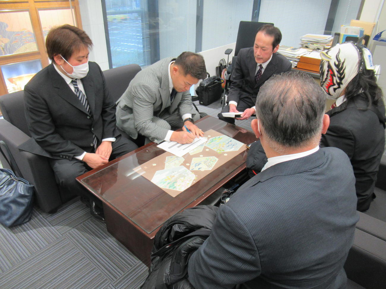 大阪プロレスのゼウス社長（左から2人目）は、義援金100万円を届けて、書類を記入した（撮影・益田一弘）