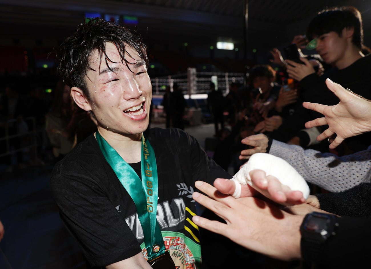 寺地対カニサレス　カニサレスに判定勝ちで防衛を果たし、ファンとタッチを交わして引き揚げる寺地（左）（撮影・前田充）