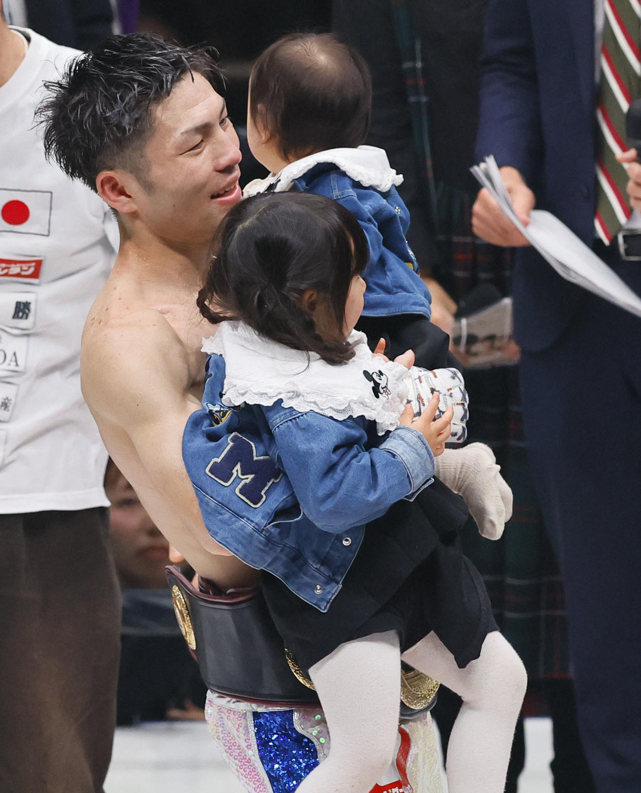 新チャンピオンに輝き、子どもを抱きかかえるユーリ阿久井（撮影・藤尾明華）