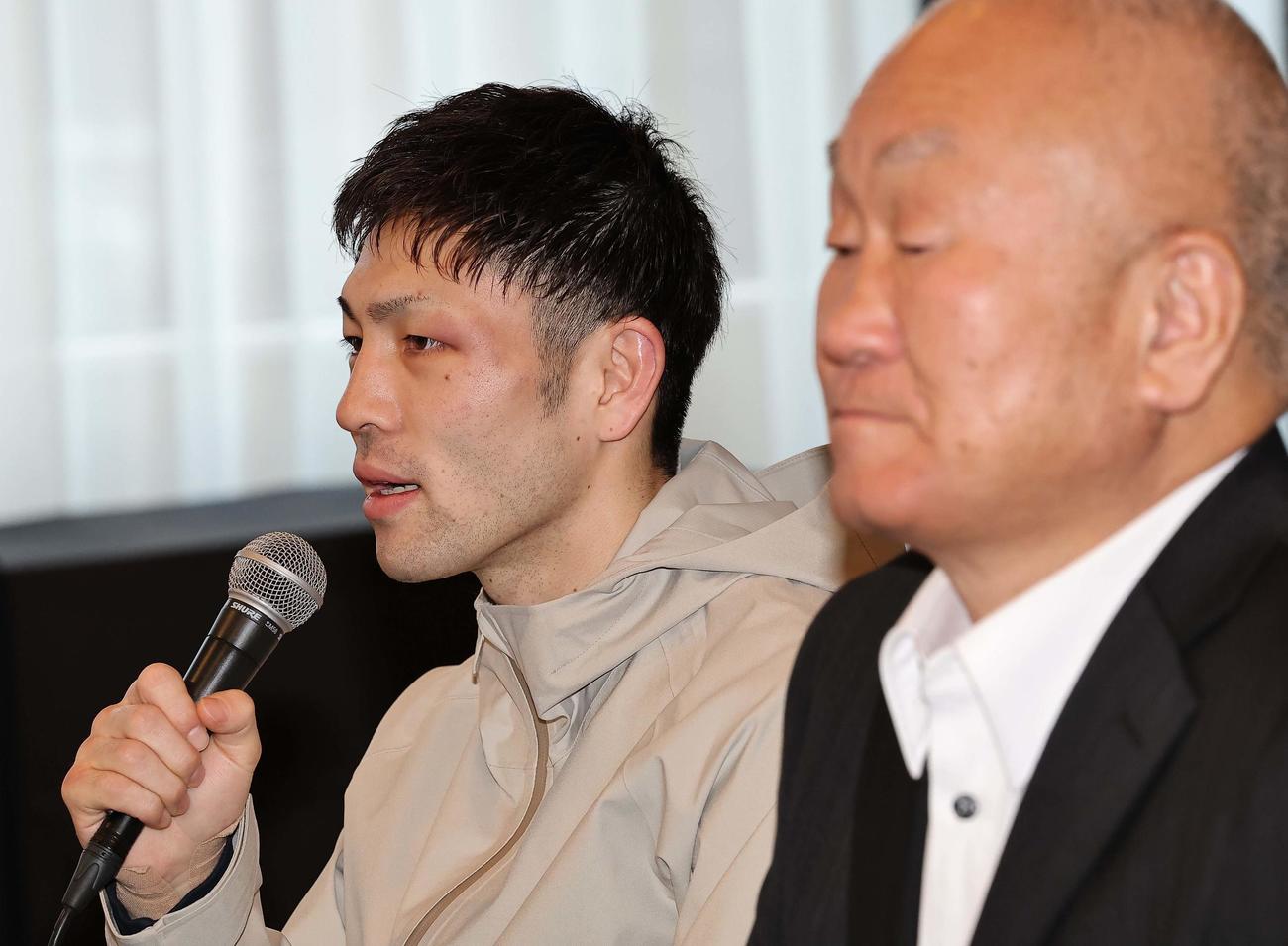 一夜明け会見で心境を話すWBAフライ級王者のユーリ阿久井政悟。右は守安ジム・守安会長（撮影・上田博志）