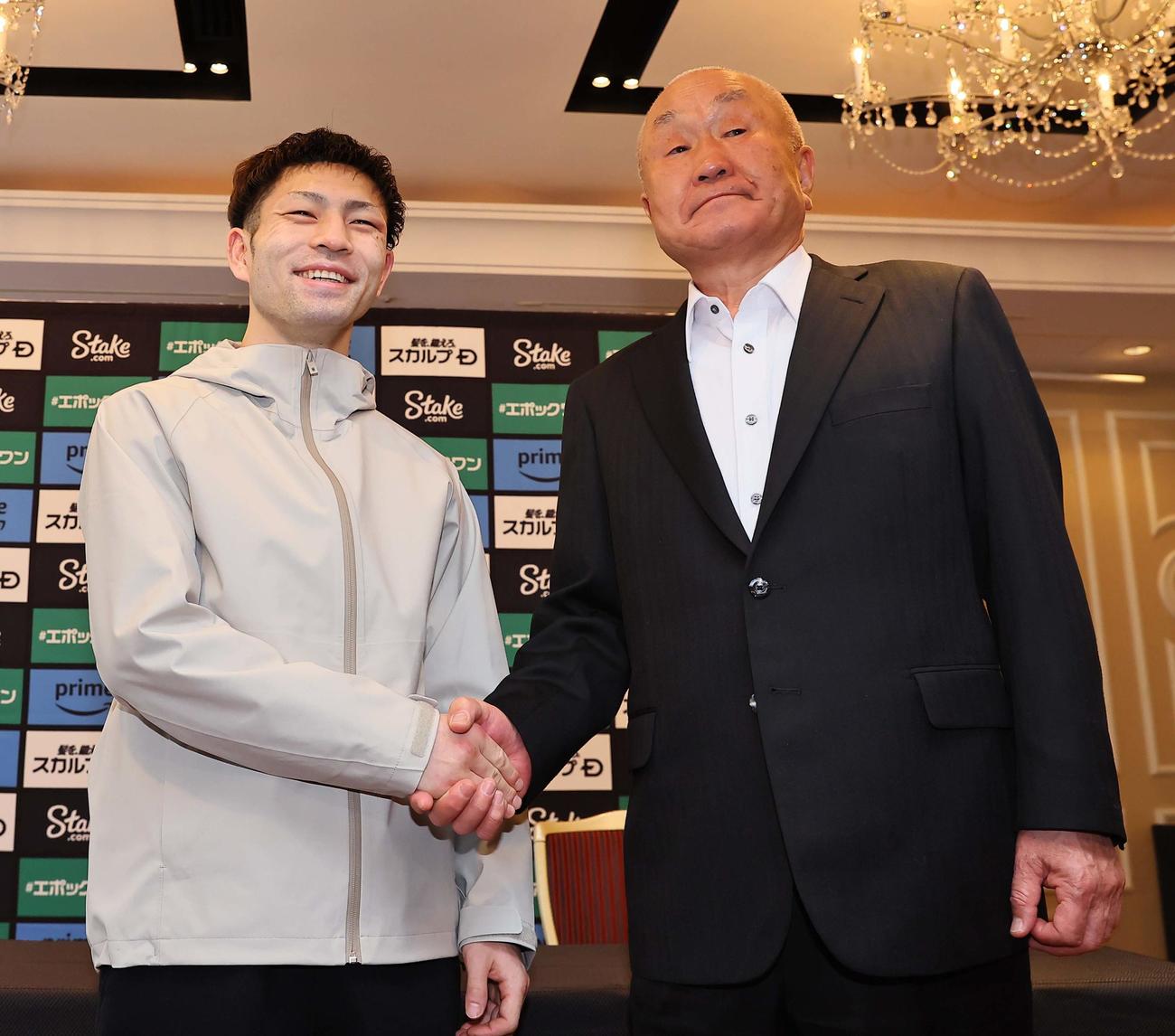 一夜明け会見で守安ジム・守安竜也会長とあくしゅを交わすWBAフライ級王者のユーリ阿久井政悟（撮影・上田博志）