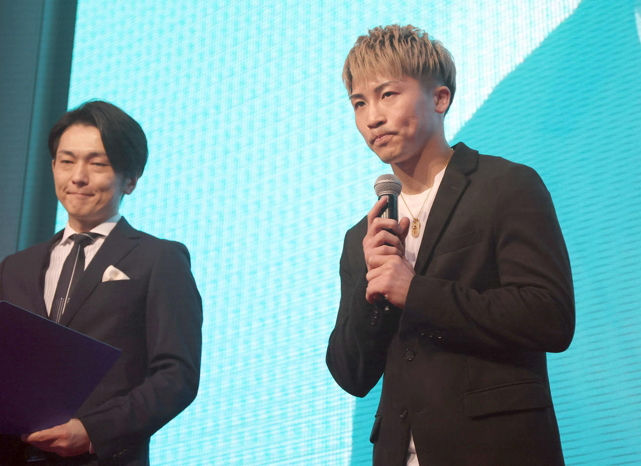 トークショーの冒頭で、亡くなった穴口一輝さんを追悼する井上（右）（代表撮影）