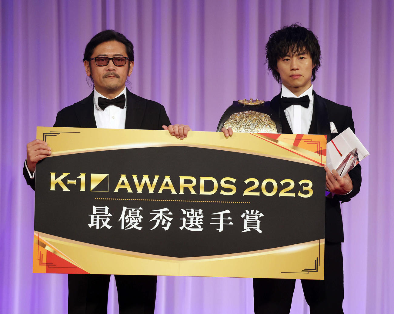 K－1 AWARDS 2023で最優秀選手賞を受賞し、カルロス菊田プロデューサー（左）と記念撮影する金子晃大（撮影・宮地輝）