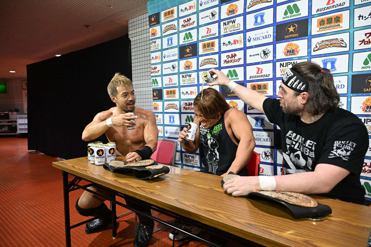 IWGPタッグ王座奪取後、乱入で貢献した石森（中央）にビールをかけるKENTA（左）とオーエンズ（写真提供・新日本プロレス）
