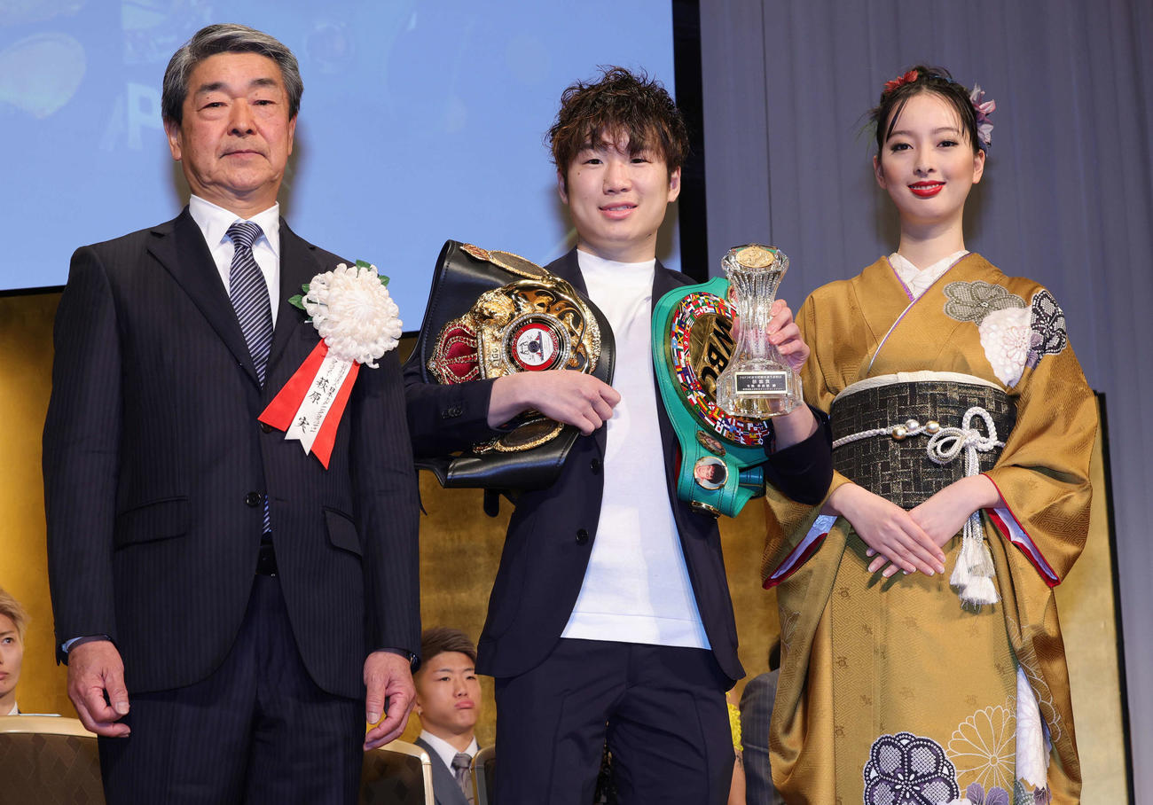 技能賞を受賞し、日本ボクシングコミッション・萩原実コミッショナー（左）、モデルの平井佑奈（右）に祝福される寺地拳四朗（撮影・野上伸悟）