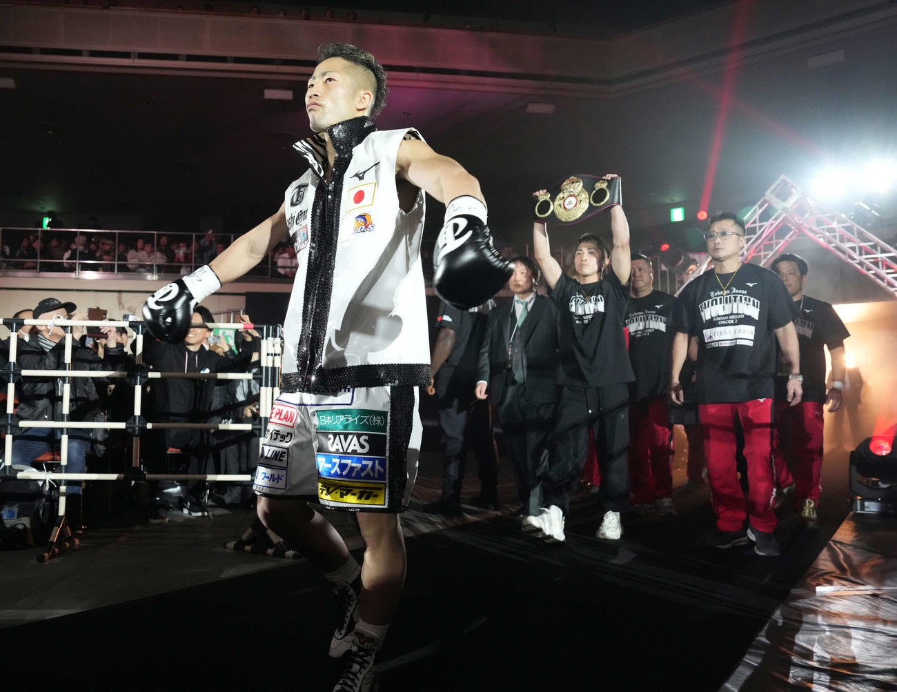 WBA世界バンタム級タイトルマッチ　井上拓対アンカハス　入場する井上拓（手前）。後方左はベルトを掲げる井上尚、右は父の真吾トレーナー（撮影・鈴木みどり）